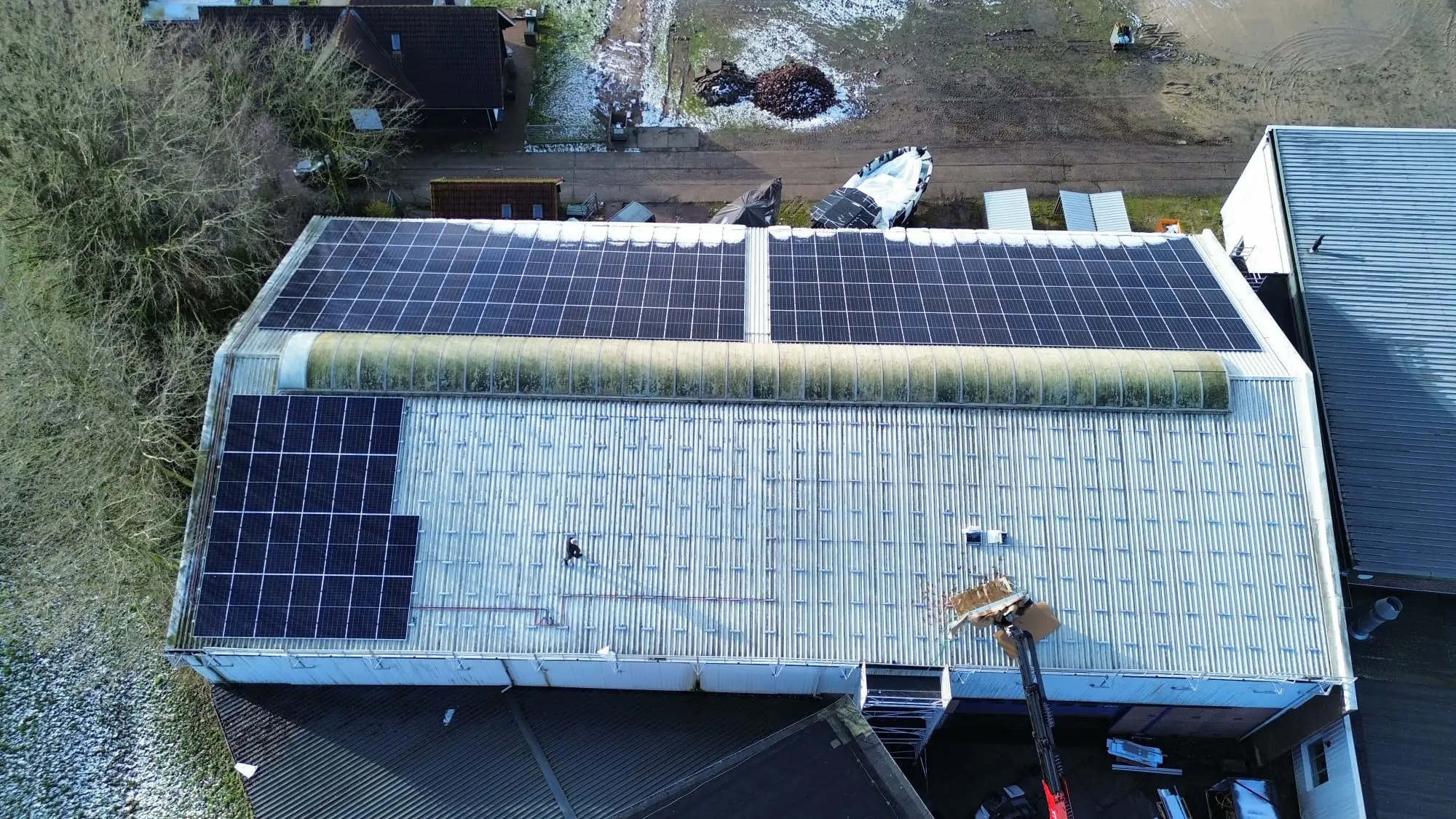 Zonnepanelen op een besneeuwd bedrijfsdak in de winter