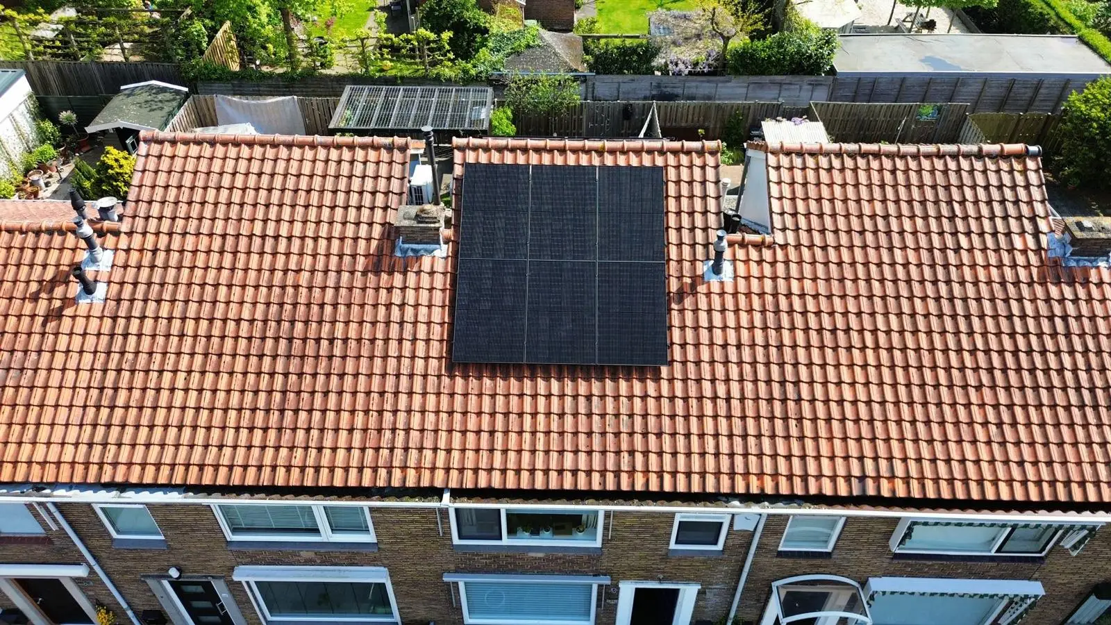 Woning met vers geïnstalleerde zonnepanelen, gefotografeerd vanuit de lucht